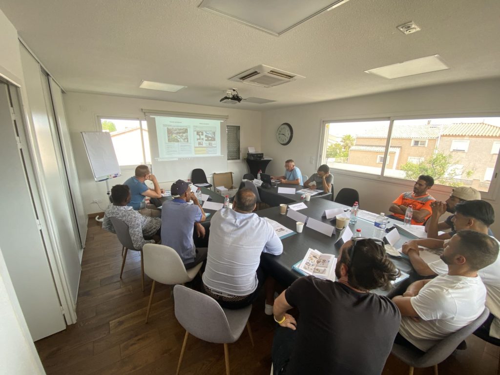 Session en cours dans la salle de formation à Perpignan, tables en U face au vidéo-projecteur