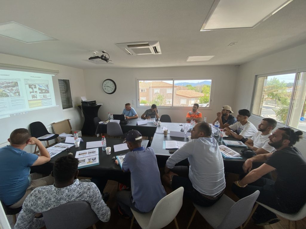 Stagiaires installés autour des tables en U dans la salle de formation à Perpignan